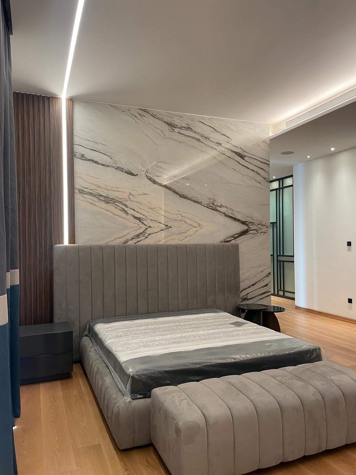 Bedroom with marble feature wall and cove lighting