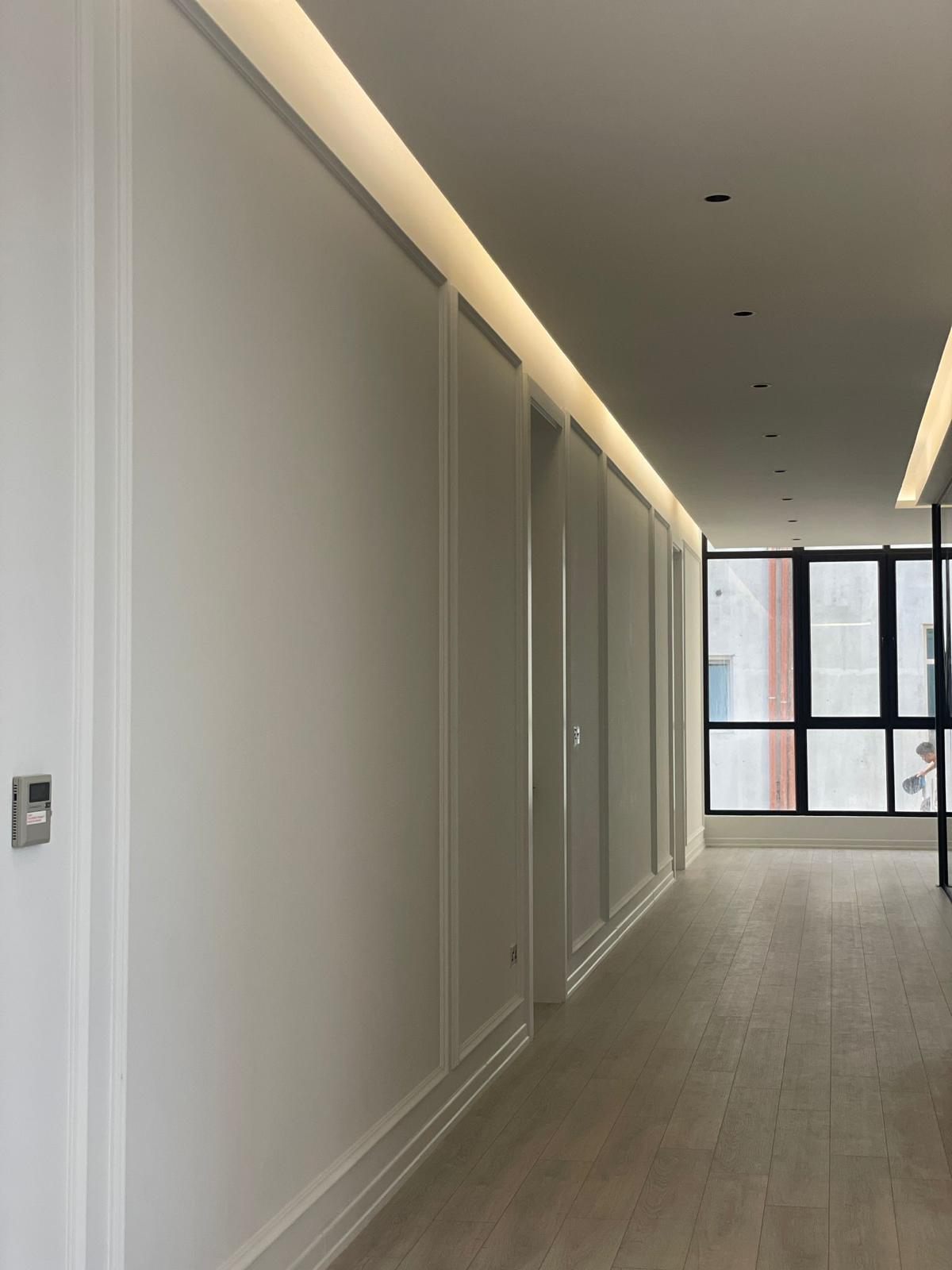 Panelled corridor with cove lighting on a live site