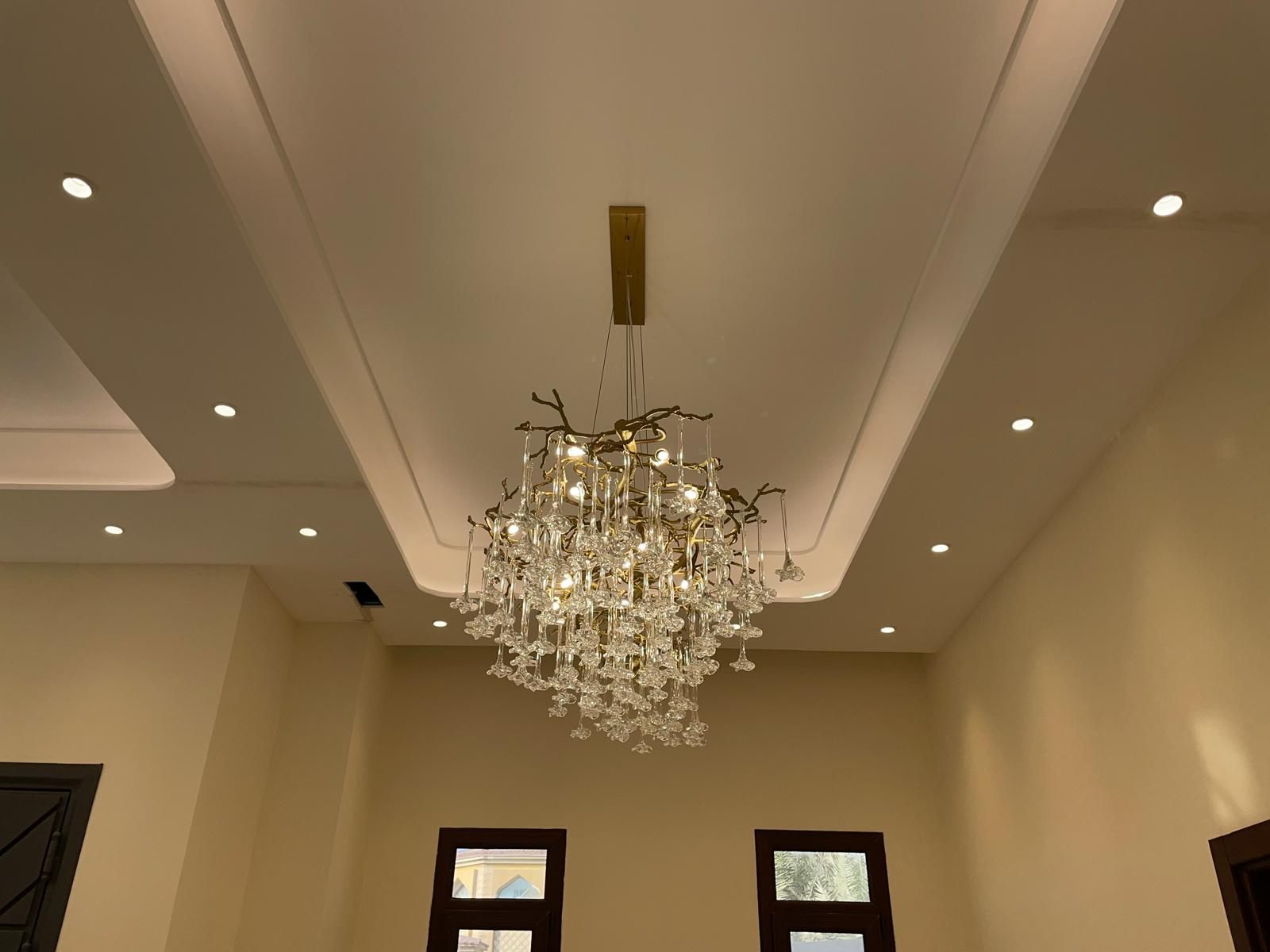 Sculptural branch-form crystal chandelier on a gypsum ceiling