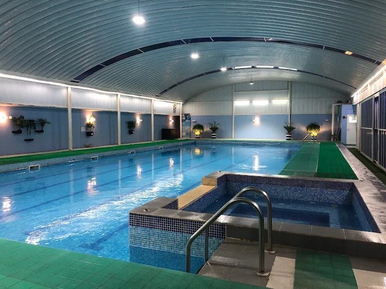 Indoor swimming pool and spa with covered roof structure